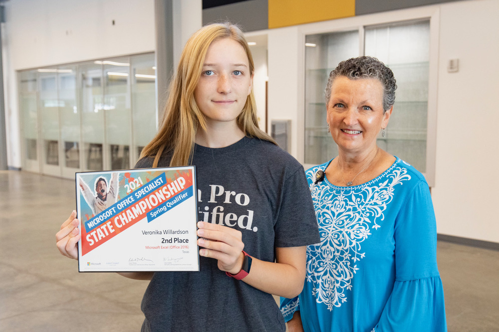 younger and older persons, the younger person is holding a certificate