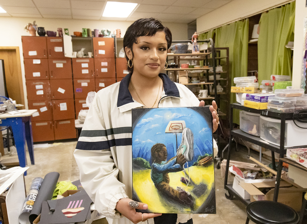 Student holding painting