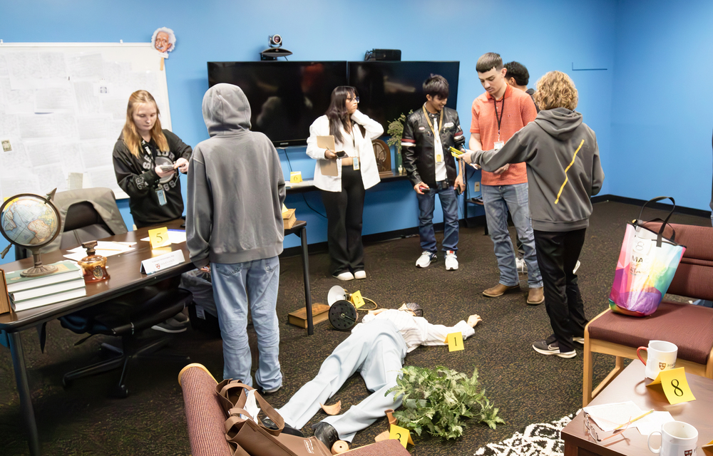 Students examine a fictional crime scene
